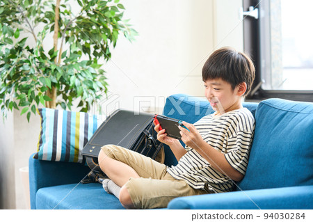 小學生坐在沙發上玩遊戲 94030284