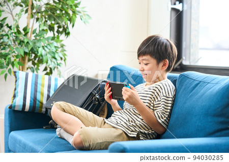 小學生坐在沙發上玩遊戲 94030285