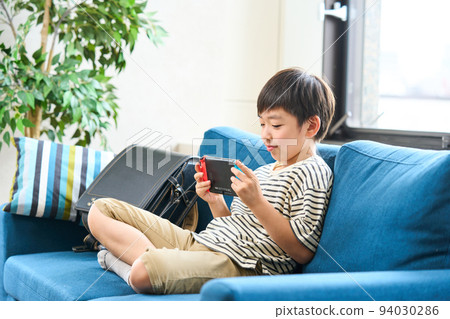 小學生坐在沙發上玩遊戲 94030286