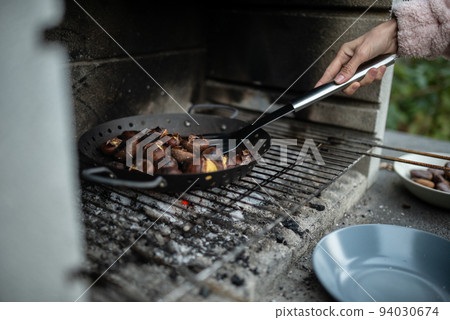 Closeup view of a woman roasting delicious chestnuts 94030674