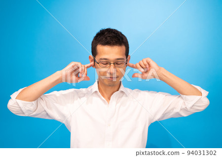 A man covering both ears with his fingers 94031302