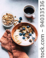 Breakfast bowl of yogurt with chocolate granola, blueberries and banana 94033536