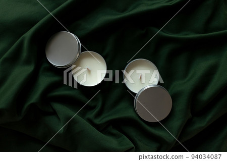 Soy candles in metal cans, handmade modern hobby , harmless coconut wax candles without paraffin on green background  94034087