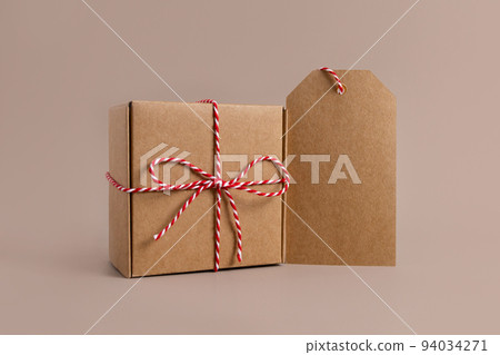 Closeup of parcels in brown wrapping paper and blank tags or labels copy space for text, isolated on beige background Closeup of parcels in brown wrapping paper and blank tags or labels copy space for text, isolated on beige background 94034271