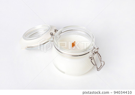 Soy candles in glass cans, handmade modern hobby , harmless coconut wax candles without paraffin with wood on white background isolated Soy candles in glass cans, handmade modern hobby , harmless coconut wax candles without paraffin with wood on white background isolated 94034410