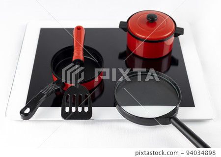 A tablet device and toy cooking utensils. Image of looking up recipes online A tablet device and toy cooking utensils. Image of looking up recipes online 94034898