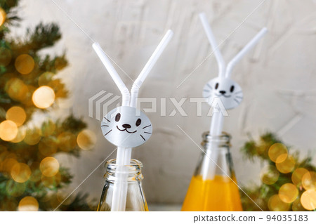 Orange drink decorated with white rabbit on light background for children party. Orange drink decorated with white rabbit on light background for children party. 94035183