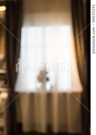 Abstract and blurry image of window with curtains with fir tree 94035243