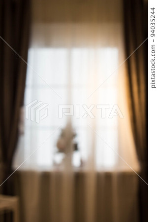Abstract and blurry image of window with curtains with fir tree 94035244