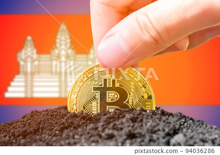 Legalization of bitcoins in Cambodia. Planting a Bitcoin in the ground against the background of the flag of Cambodia. Cambodia - investment in cryptocurrency. Legalization of bitcoins in Cambodia. Planting a Bitcoin in the ground against the background of the flag of Cambodia. Cambodia - investment in cryptocurrency. 94036286