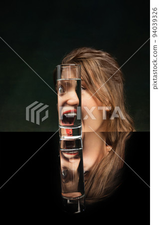 Scream. Modern art photography. Beautiful girl's face through glass of water. Object distortion, optical illusion. Minimalistic contemporary art. Scream. Modern art photography. Beautiful girl's face through glass of water. Object distortion, optical illusion. Minimalistic contemporary art. 94039326