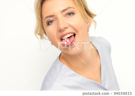Waxing, depilation, hair removal concept. Happy young caucasian beautician with candy in her mouth looking at the camera on white background 94039833
