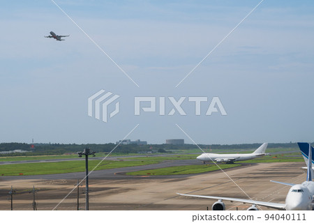 一架從成田機場跑道起飛的客機和一架準備起飛的白色巨型貨機 94040111