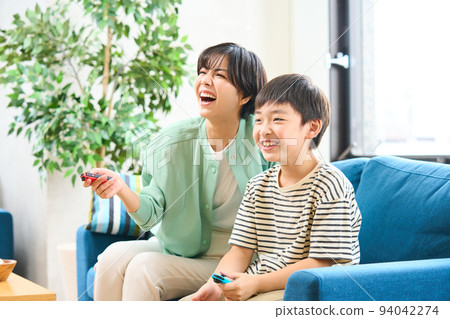 父母和孩子坐在沙發上玩遊戲，母子 94042274