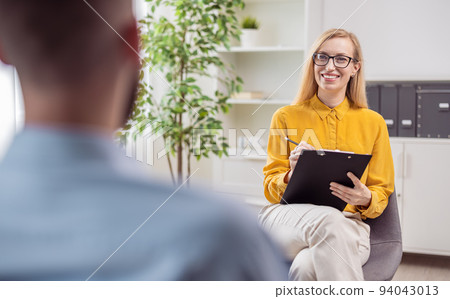 Psychologist smiling to patient Psychologist smiling to patient 94043013