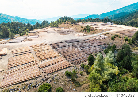 Aerial view of sawmill with timber, chopped a lot of pine tree wood logs. Top, drone view Aerial view of sawmill with timber, chopped a lot of pine tree wood logs. Top, drone view 94043358