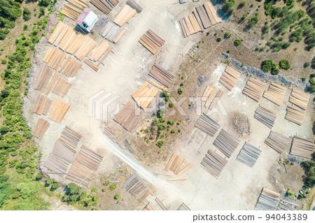 Aerial view of sawmill with timber, chopped a lot of pine tree wood logs. Top, drone view Aerial view of sawmill with timber, chopped a lot of pine tree wood logs. Top, drone view 94043389