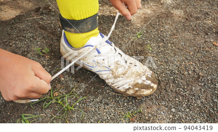 boy tying soccer shoe laces boy tying soccer shoe laces 94043419