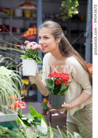 nice european girl looking at flowers in shop 94043678