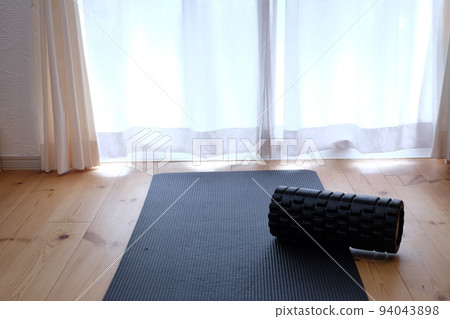 在客廳伸展瑜伽墊和筋膜滾輪 在客廳伸展瑜伽墊和筋膜滾輪 94043898