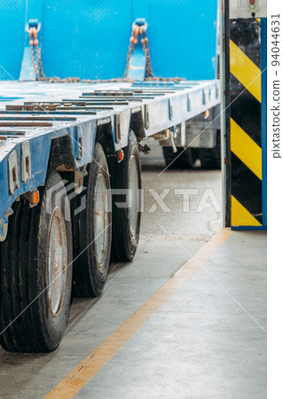 Platform of car with wheels is in garage. Rear view. Heavy machinery. Trawl or tractor. 94044631