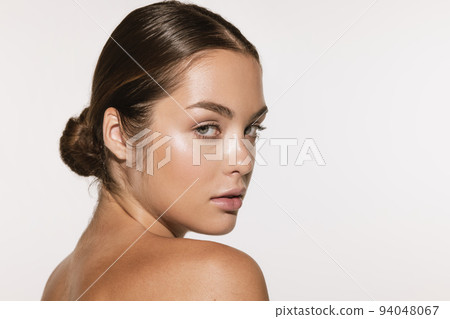 Closeup portrait of beautiful young girl with clean well-kept skin isolated over white background. Skin care. Facial treatment. Cosmetology, beauty and spa. Closeup portrait of beautiful young girl with clean well-kept skin isolated over white background. Skin care. Facial treatment. Cosmetology, beauty and spa. 94048067