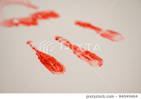 Hand prints in blood on a white table.  94049464
