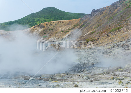 steaming hydrothermal outlet on the shore of the hot lake in the caldera of the Golovnin volcano on the island of Kunashir steaming hydrothermal outlet on the shore of the hot lake in the caldera of the Golovnin volcano on the island of Kunashir 94052745