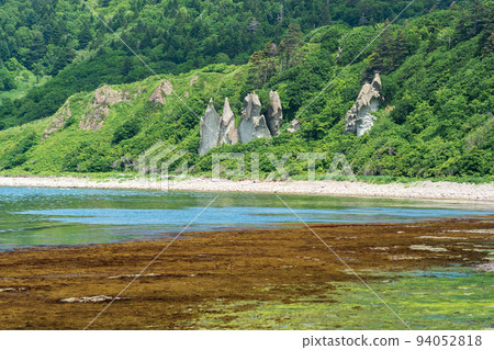 coastal landscape, beautiful lava rocks on the green coast of Kunashir island, algae on the littoral at low tide coastal landscape, beautiful lava rocks on the green coast of Kunashir island, algae on the littoral at low tide 94052818