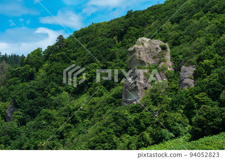 coastal landscape, beautiful lava rocks on the wooded coast of Kunashir island 94052823
