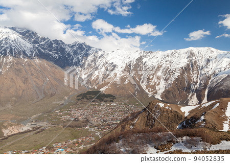Aerial view of Stepantsminda townlet on a sunny day 94052835