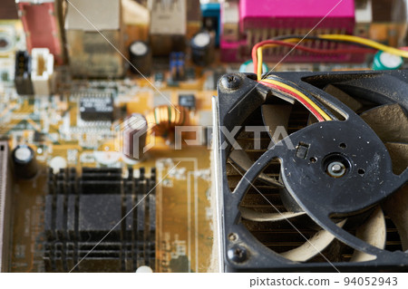 Old motherboard covered in dust and dirt. Close-up. 94052943