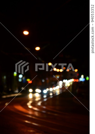 Blurred night scene of traffic on the roadway. Defocused image of cars traveling with luminous headlights. Bokeh Art 94053352