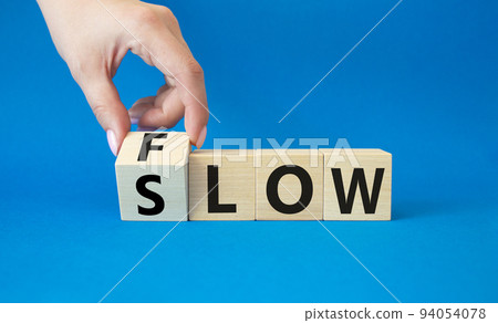 Flow and Slow symbol. Concept words Flow and Slow on wooden cubes. Beautiful blue background. Businessman hand. Business and Flow and Slow concept. Copy space. Flow and Slow symbol. Concept words Flow and Slow on wooden cubes. Beautiful blue background. Businessman hand. Business and Flow and Slow concept. Copy space. 94054078