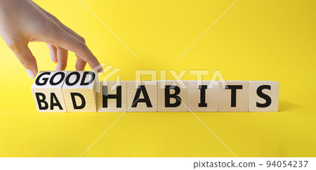 Good and bad Habits symbol. Businessman hand Turnes wooden cubes and changes words Bad Habits to Good Habits. Beautiful yellow background. Medicine concept. Copy space 94054237