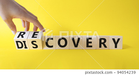 Recovery and Discovery. Businessman hand Turnes wooden cubes and changes word Discovery to Recovery. Beautiful yellow background. Business concept. Copy space Recovery and Discovery. Businessman hand Turnes wooden cubes and changes word Discovery to Recovery. Beautiful yellow background. Business concept. Copy space 94054239