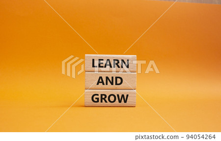 Learn and grow symbol. Concept words 'Learn and grow' on wooden blocks. Beautiful orange background. Business and Learn and grow concept. Copy space. Learn and grow symbol. Concept words 'Learn and grow' on wooden blocks. Beautiful orange background. Business and Learn and grow concept. Copy space. 94054264