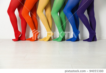 Women wearing colorful tights near white wall, closeup 94055380