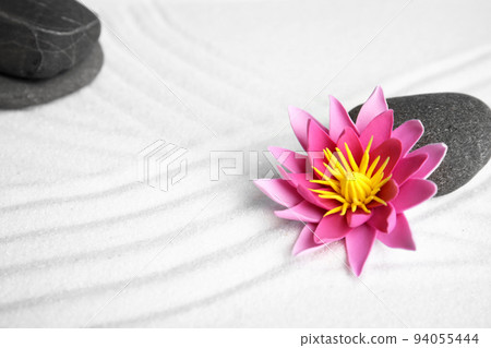 Zen garden. Beautiful lotus flower and stone on white sand Zen garden. Beautiful lotus flower and stone on white sand 94055444