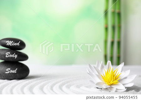 Stones with words Mind, Body, Soul and lotus flower on white sand. Zen garden Stones with words Mind, Body, Soul and lotus flower on white sand. Zen garden 94055455