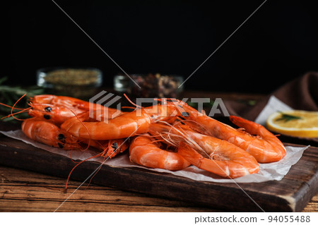 Delicious cooked shrimps on wooden table against black background 94055488