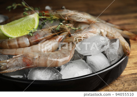Fresh raw shrimps with ice on table, closeup Fresh raw shrimps with ice on table, closeup 94055510