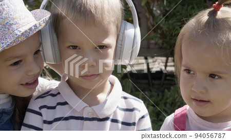 Three cute little Children enjoys delicious ice cream cone. Child eating watermelon popsicle. Kids Siblings snack sweets in Home Garden. Summer holiday Hot weather Sunny Day. Childhood, Food Candy 94056787