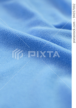 The blanket of furry blue fleece fabric. A background of light blue soft plush fleece material with a lot of relief folds 94057002