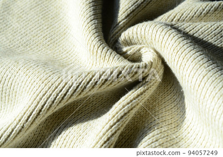 Fabric texture of a soft yellow knitted sweater. Macro image of the structure of bindings in yarns Fabric texture of a soft yellow knitted sweater. Macro image of the structure of bindings in yarns 94057249