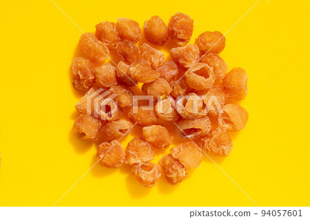 Dried longan on yellow background. 94057601