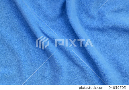 The blanket of furry blue fleece fabric. A background of light blue soft plush fleece material with a lot of relief folds 94059705