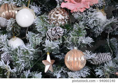 Decorating Christmas tree close up. Decoration bulb, snowy green fir tree, pink x-mas toys and lights. Use for Christmas and New years celebration background Decorating Christmas tree close up. Decoration bulb, snowy green fir tree, pink x-mas toys and lights. Use for Christmas and New years celebration background 94060140