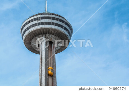 Niagara Falls, Ontario Canada - August 29, 2019: Beautiful view of skylon tower at Niagara falls with blue sky and green trees. Niagara Falls, Ontario Canada - August 29, 2019: Beautiful view of skylon tower at Niagara falls with blue sky and green trees. 94060274