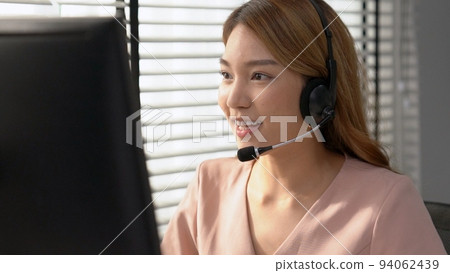 Competent female operator working on computer and while talking with clients. Competent female operator working on computer and while talking with clients. 94062439